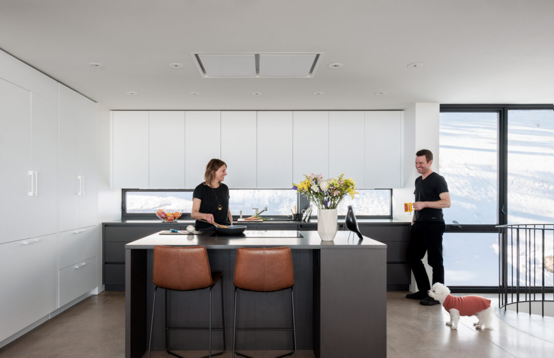 Flat panel kitchen cabinetry in ultramatte pure white with dark island storage in Golden home