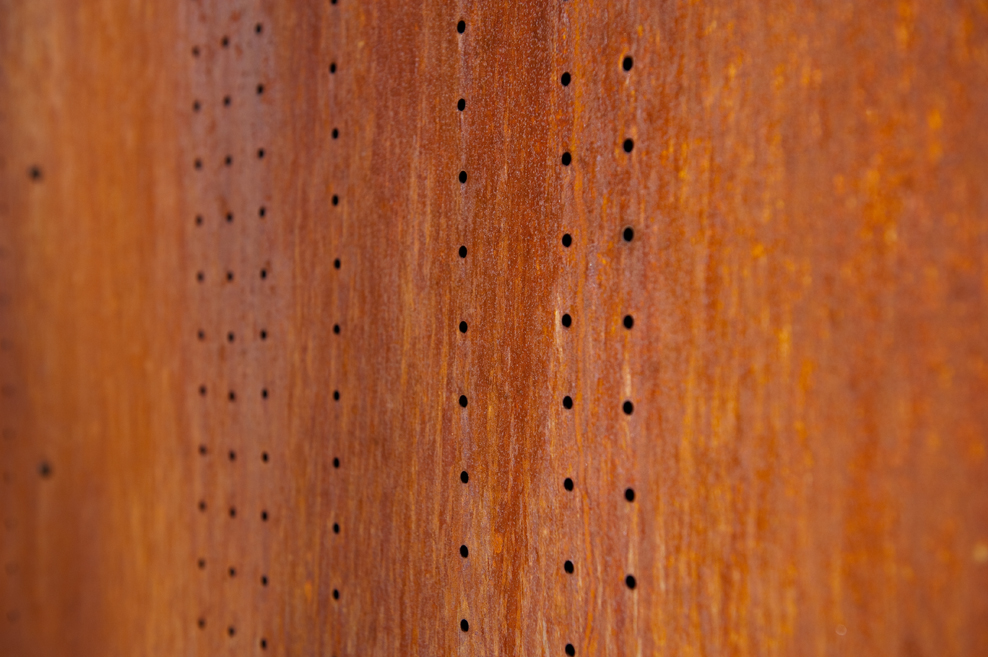Close-up detail of perforated corten steel cladding on the Vonmod building in Denver