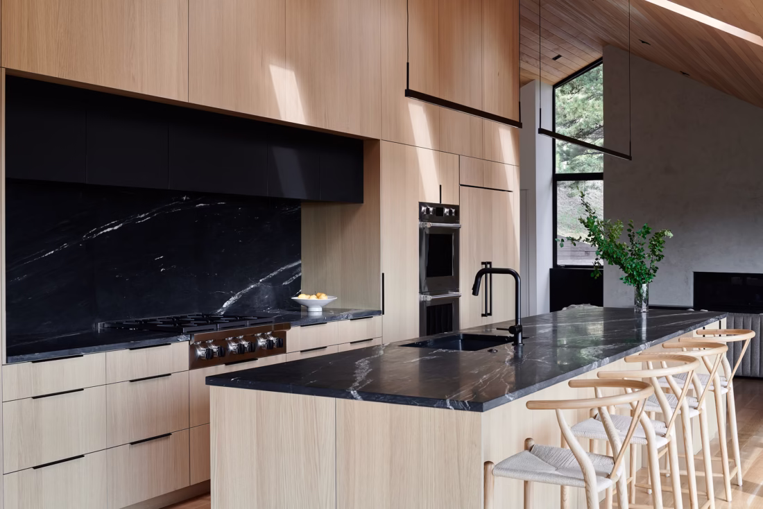 Ivory oak kitchen cabinetry with dark island and integrated storage in Boulder residence
