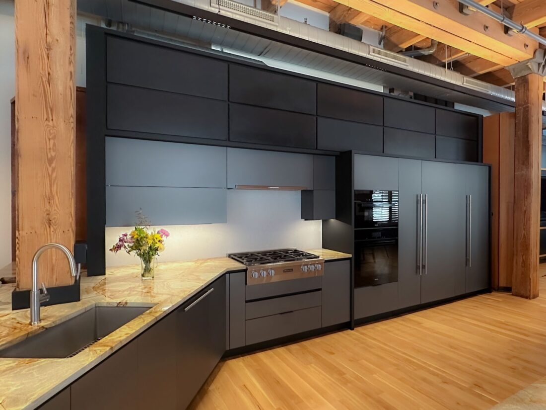 Metallic grey kitchen cabinetry with integrated range and stone countertops in Denver residence
