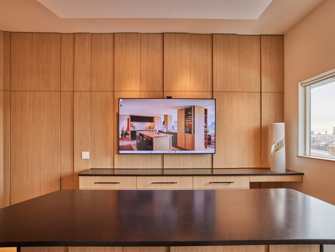 Wood-paneled meeting room with integrated media wall and Denver city views in Vonmod showroom