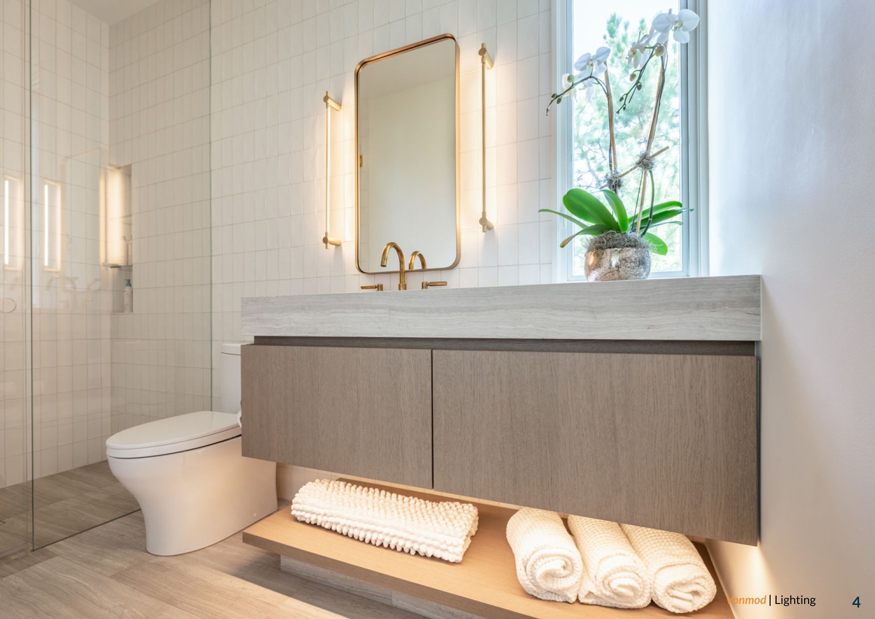 Bathroom vanity with integrated under-cabinet lighting and vertical mirror lighting above a floating cabinet.